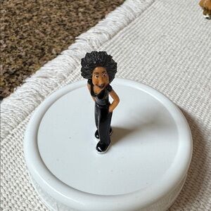 The figurine is "Bruja" from Series 6 of the collectible toy line, Homies.